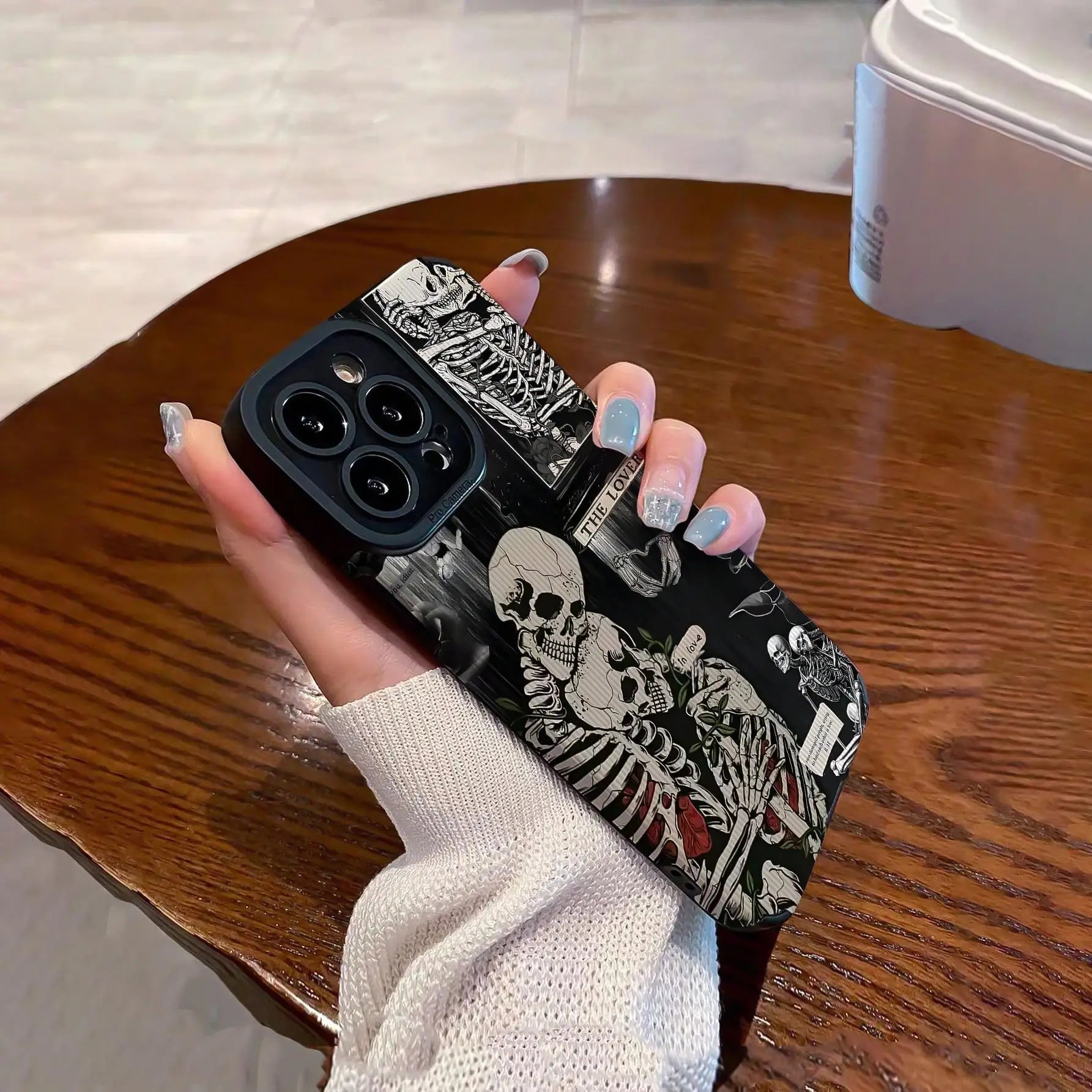 Skull pattern anti-slip phone case for iPhone 16 Pro Max to X/XS on wooden table.